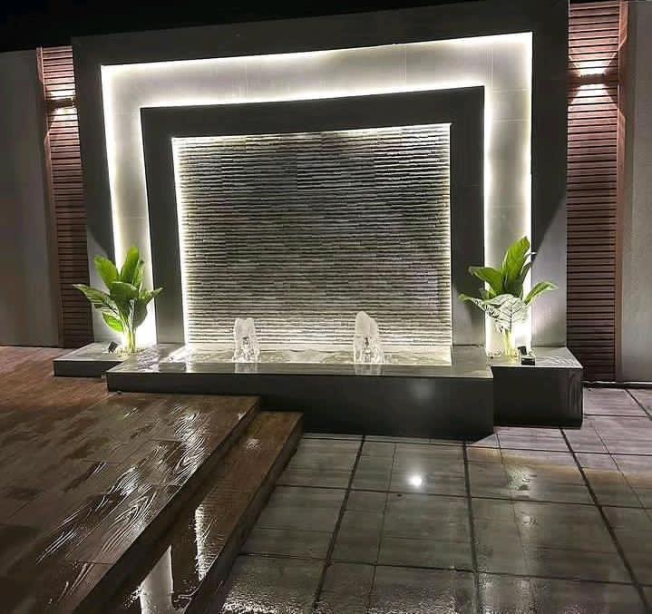 تنفيذ شلال جداري مودرن مع اضاءة ليد مخفية بجدة - تصميم شلال ماء زجاجي مضيء مع نافورتين واحواض زرع وارضية بديل خشب